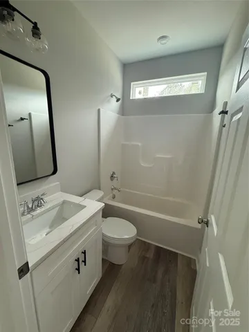 a bathroom with a sink a toilet a mirror and shower