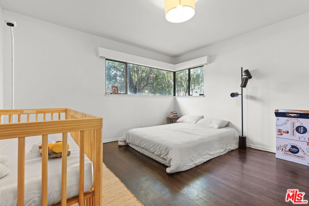 3765 Arbolada Road Los Angeles, CA 90027 - Photo 12 of 34 a bedroom with a bed a large window with wooden floor
