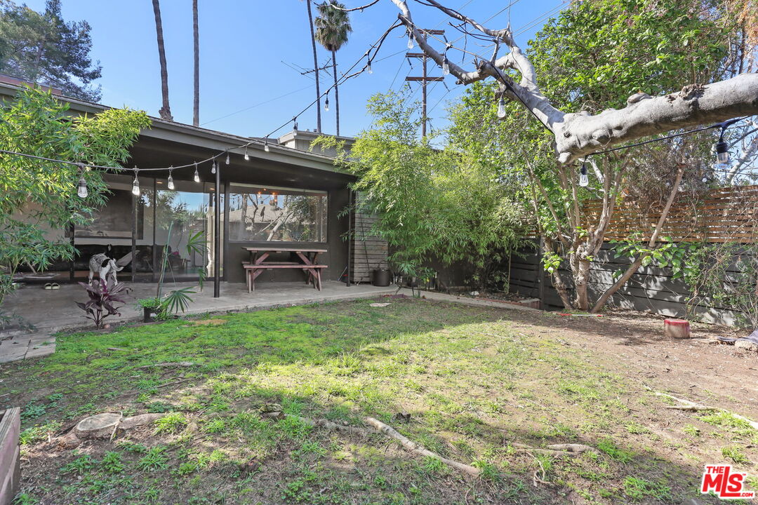 3765 Arbolada Road Los Angeles, CA 90027 - Photo 16 of 34 a view of a backyard with table and chairs and potted plants