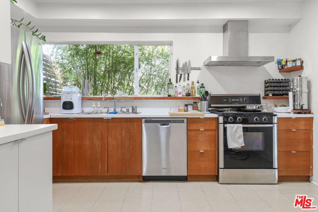 3765 Arbolada Road Los Angeles, CA 90027 - Photo 5 of 34 a kitchen with stainless steel appliances granite countertop a stove a sink and a microwave
