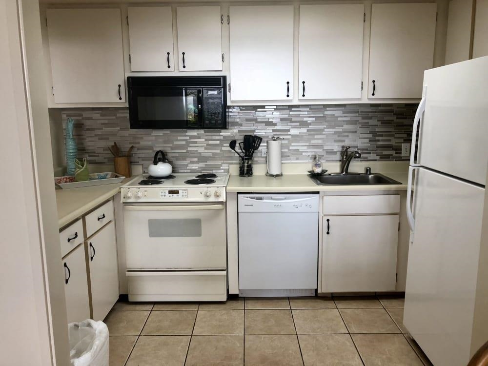 3875 Lower Honoapiilani Road, Unit A105 Lahaina, HI 96761 - Photo 11 of 27 a kitchen with white cabinets and white appliances