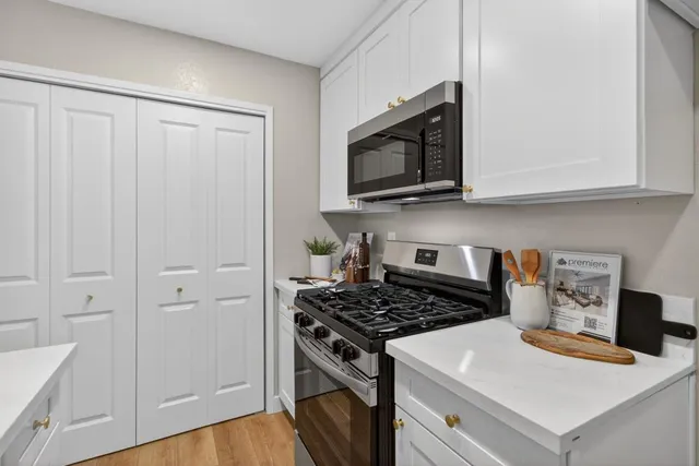 a kitchen with white cabinets and appliances