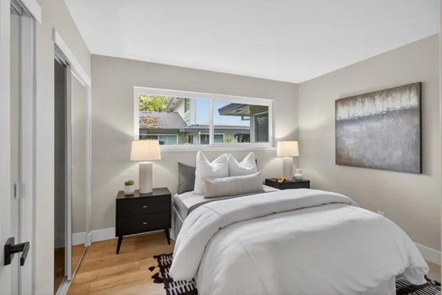 a bedroom with a bed and a painting on the wall