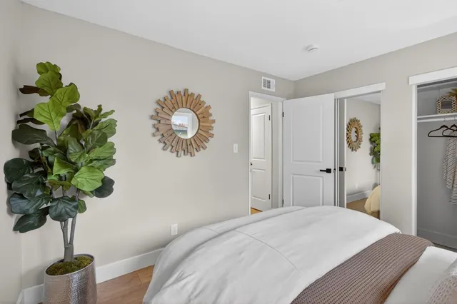 a bedroom with a bed and a potted plant