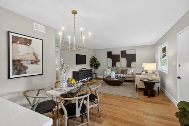 a living room with furniture a flat screen tv and kitchen view