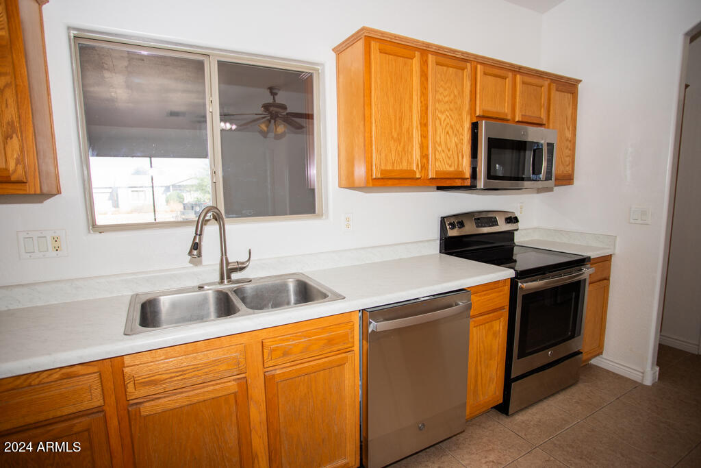 20526 West Teepee Road Buckeye, AZ 85326 - Photo 62 of 69 a kitchen with stainless steel appliances granite countertop a sink and a microwave
