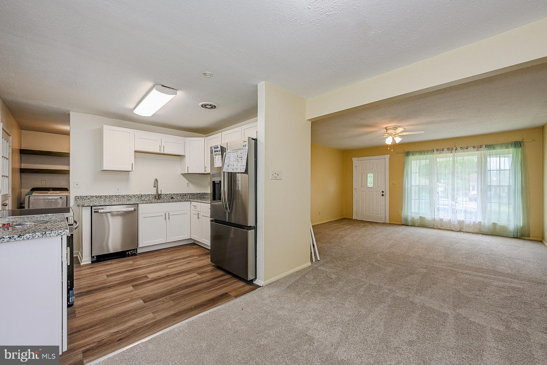 6728 Bowie Drive Springfield, VA 22150 - Photo 8 of 26 a view of a kitchen with a sink and dishwasher a refrigerator with white cabinets