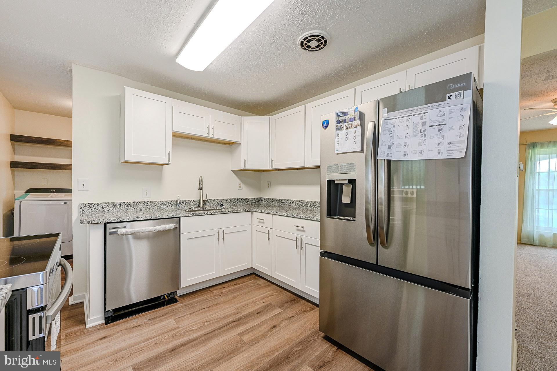 6728 Bowie Drive Springfield, VA 22150 - Photo 10 of 26 a kitchen with stainless steel appliances granite countertop a refrigerator and a stove top oven