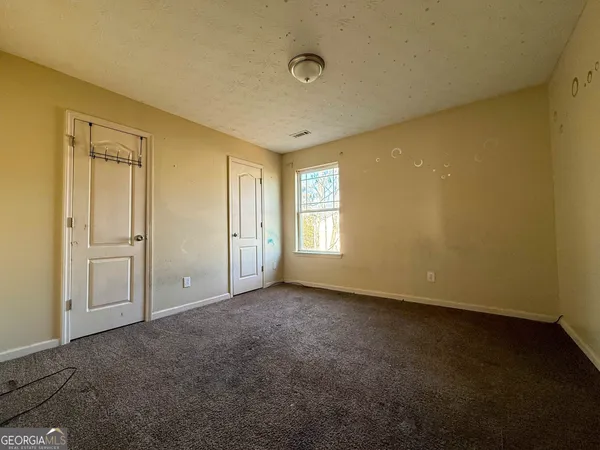 an empty room with windows and closet