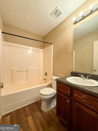 a bathroom with a sink a toilet a mirror and shower