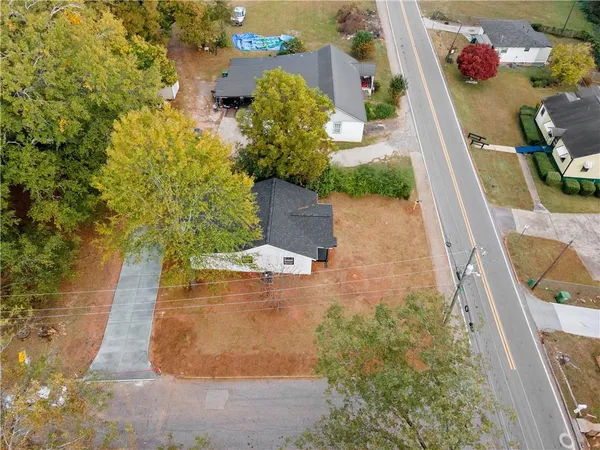 an aerial view of a house with a yard and large trees