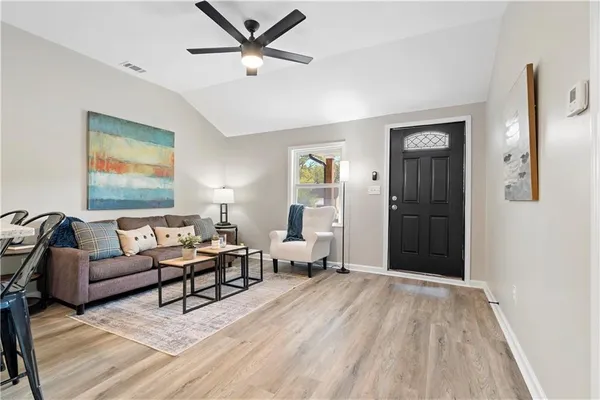 a living room with furniture and a wooden floor