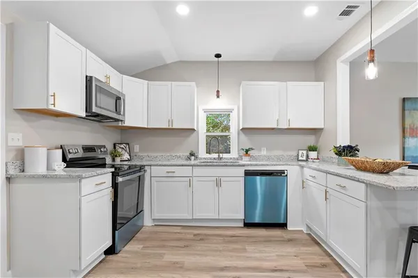 a kitchen with stainless steel appliances granite countertop a stove sink and cabinets