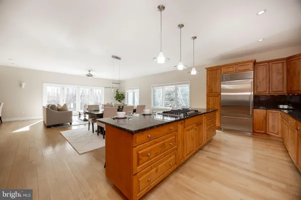 a large kitchen with stainless steel appliances granite countertop a stove and a wooden floors