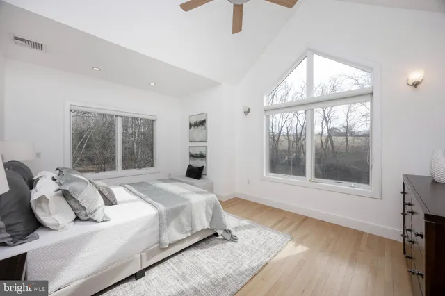 a bedroom with a bed and a large window