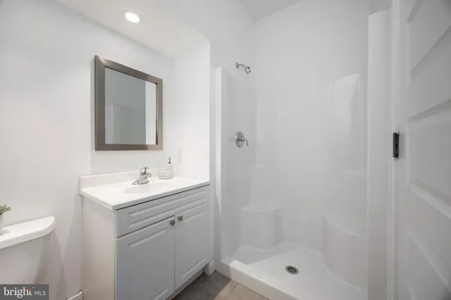 a bathroom with a toilet a sink a mirror and shower