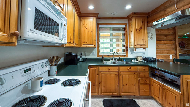 143 East Chestnut Street Helper, UT 84526 - Photo 7 of 35 Kitchen featuring white appliances, wood finish cabinets, dark countertops, log walls, and recessed lighting