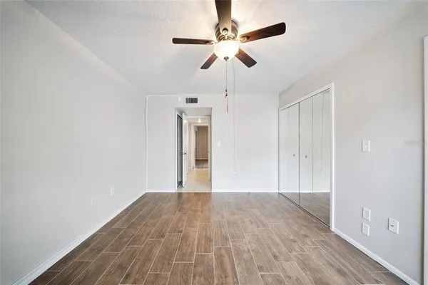 a view of empty room with wooden floor