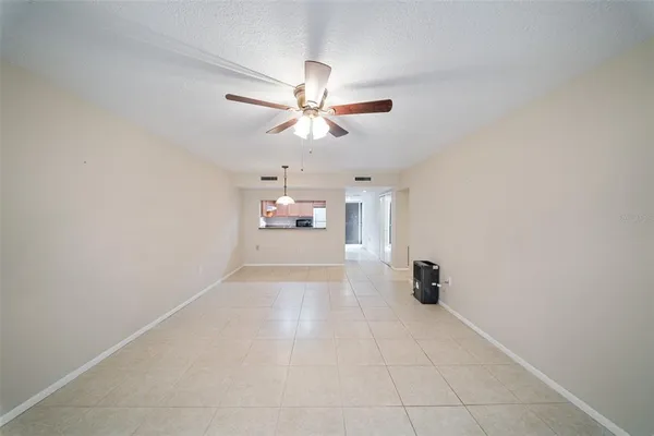 an empty room with closet and a chandelier fan