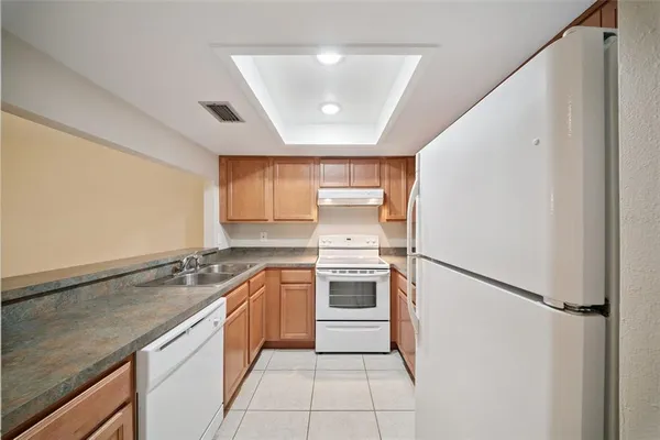 a kitchen with a stove a refrigerator and a sink