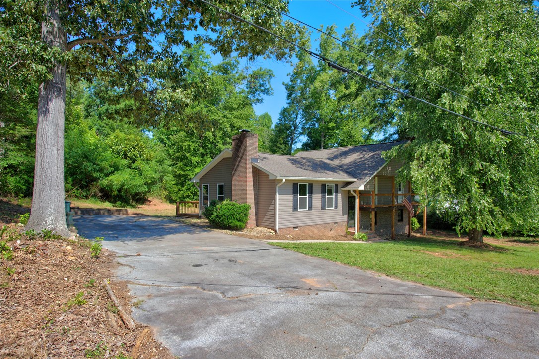 712 Beech Drive Seneca, SC 29678 - Photo 3 of 41 Mature trees frame this charming residence, offering privacy and a spacious driveway.