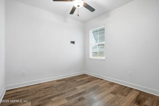 wooden floor in an empty room with a window