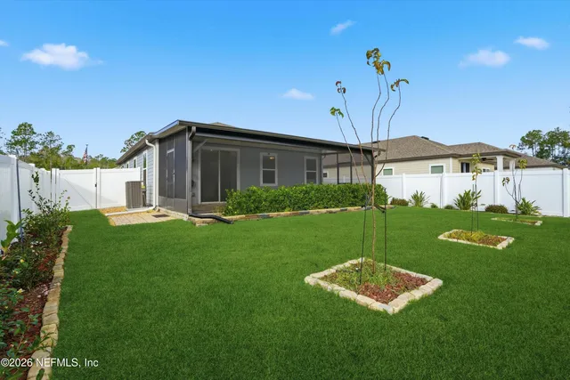a view of a house with backyard and a garden