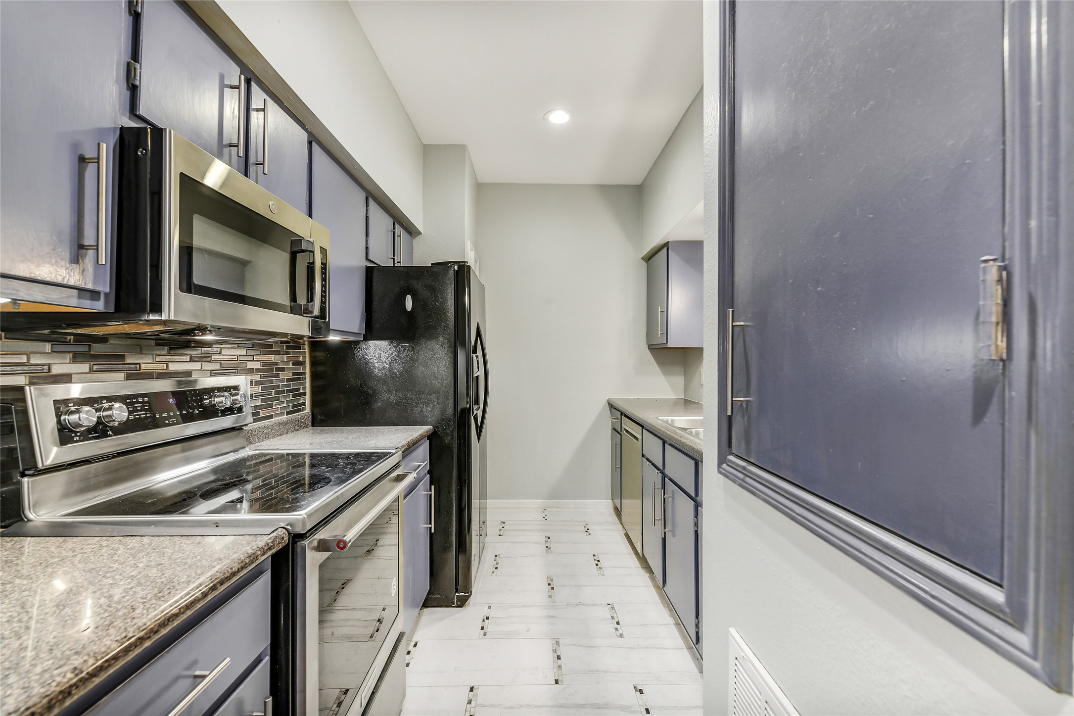 4001 Tanglewilde Street, Unit 1402 Houston, TX 77063 - Photo 8 of 23 a kitchen with stainless steel appliances granite countertop a refrigerator and a stove