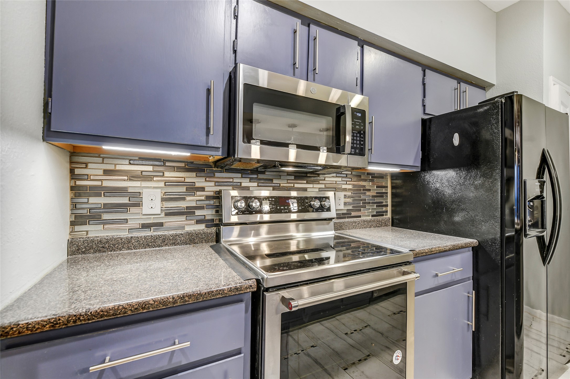 4001 Tanglewilde Street, Unit 1402 Houston, TX 77063 - Photo 9 of 23 a stove top oven sitting inside of a kitchen