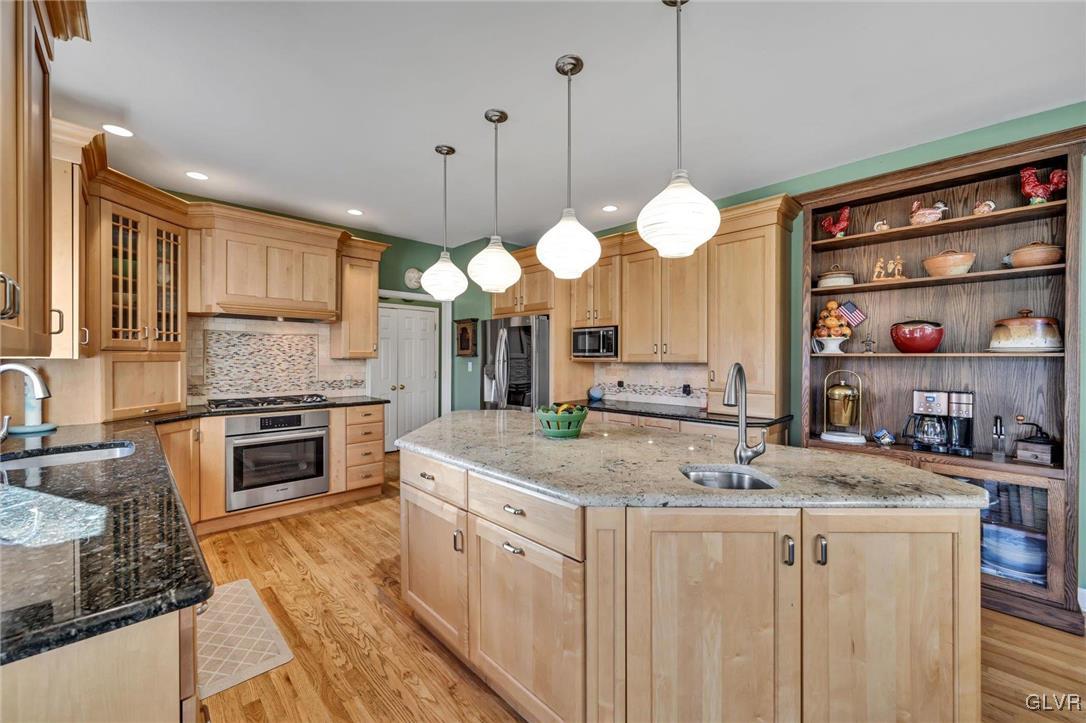 330 Manor Drive Nazareth, PA 18064 - Photo 9 of 51 a kitchen with stainless steel appliances granite countertop a stove a sink and a wooden floors