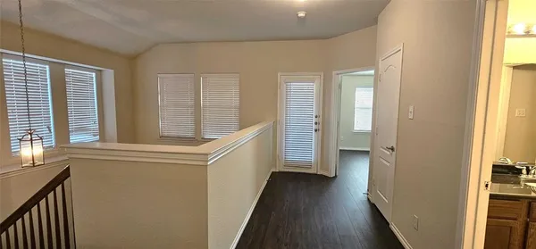 a view of a hallway with wooden floor and staircase