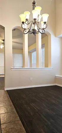 a view of a room with wooden floor and a chandelier
