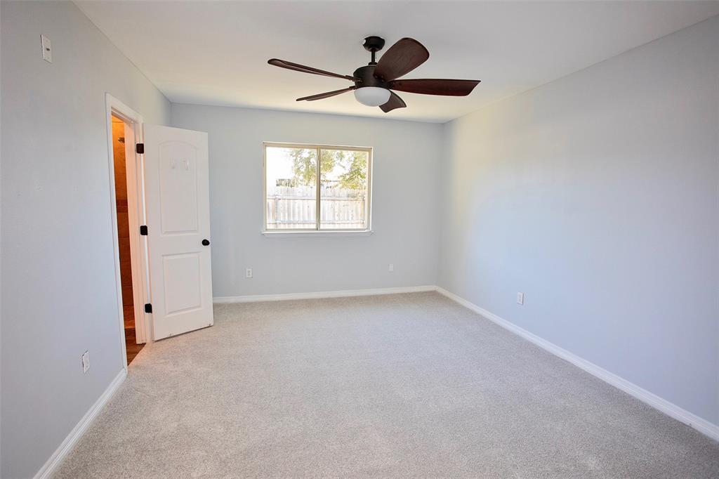 1214 3rd Street Graham, TX 76450 - Photo 12 of 23 an empty room with a window and a fan
