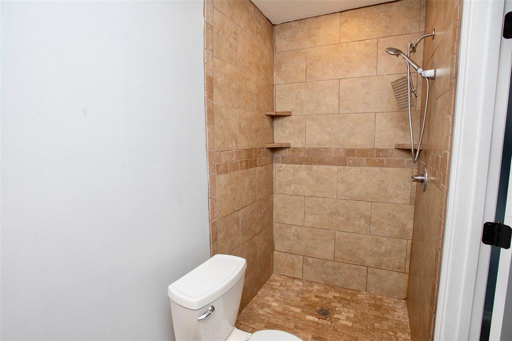 1214 3rd Street Graham, TX 76450 - Photo 14 of 23 a bathroom with a toilet and a shower