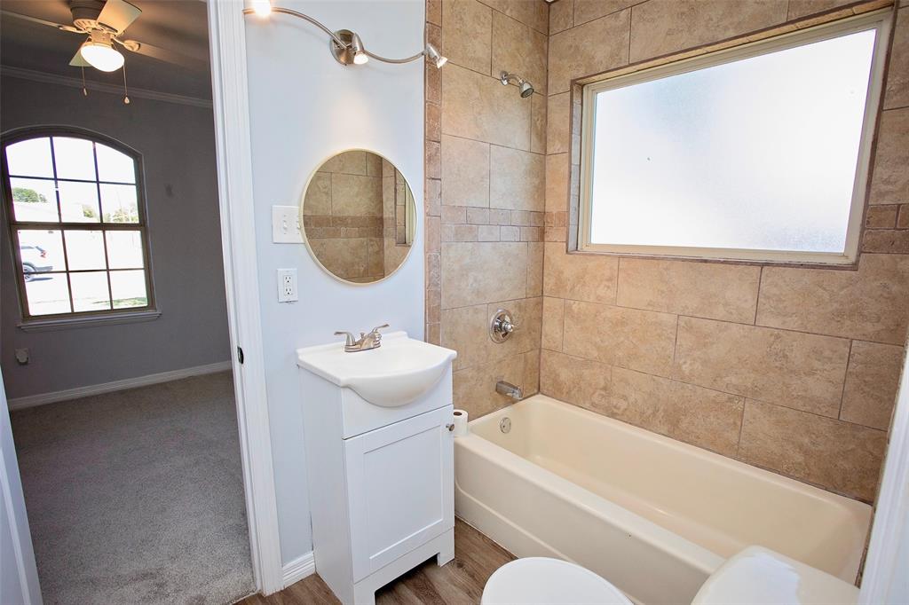 1214 3rd Street Graham, TX 76450 - Photo 19 of 23 a bathroom with a sink a bathtub and a shower
