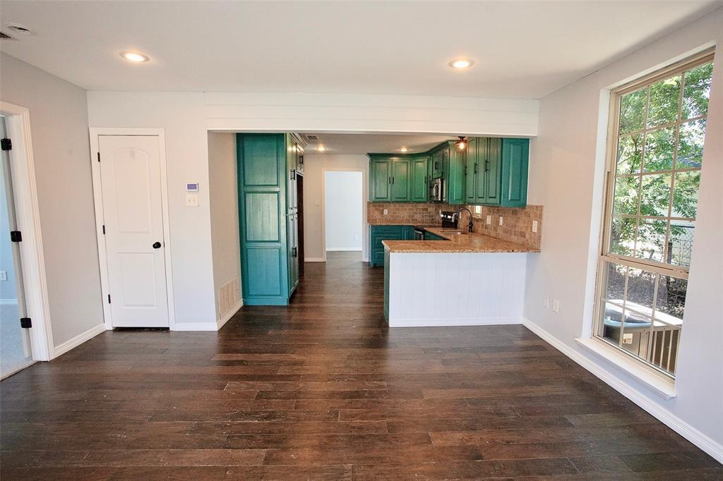 1214 3rd Street Graham, TX 76450 - Photo 2 of 23 a view of a living room a kitchen and a wooden floor