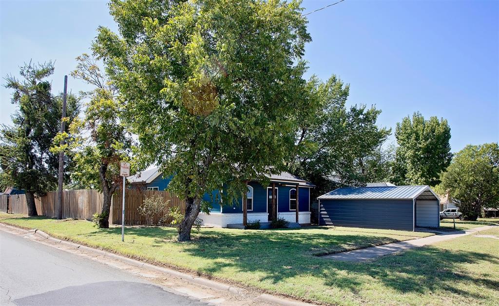 1214 3rd Street Graham, TX 76450 - Photo 3 of 23 a white house that has a tree in front of it