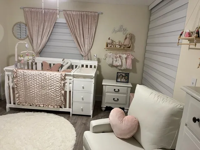 a living room with furniture and a baby crib