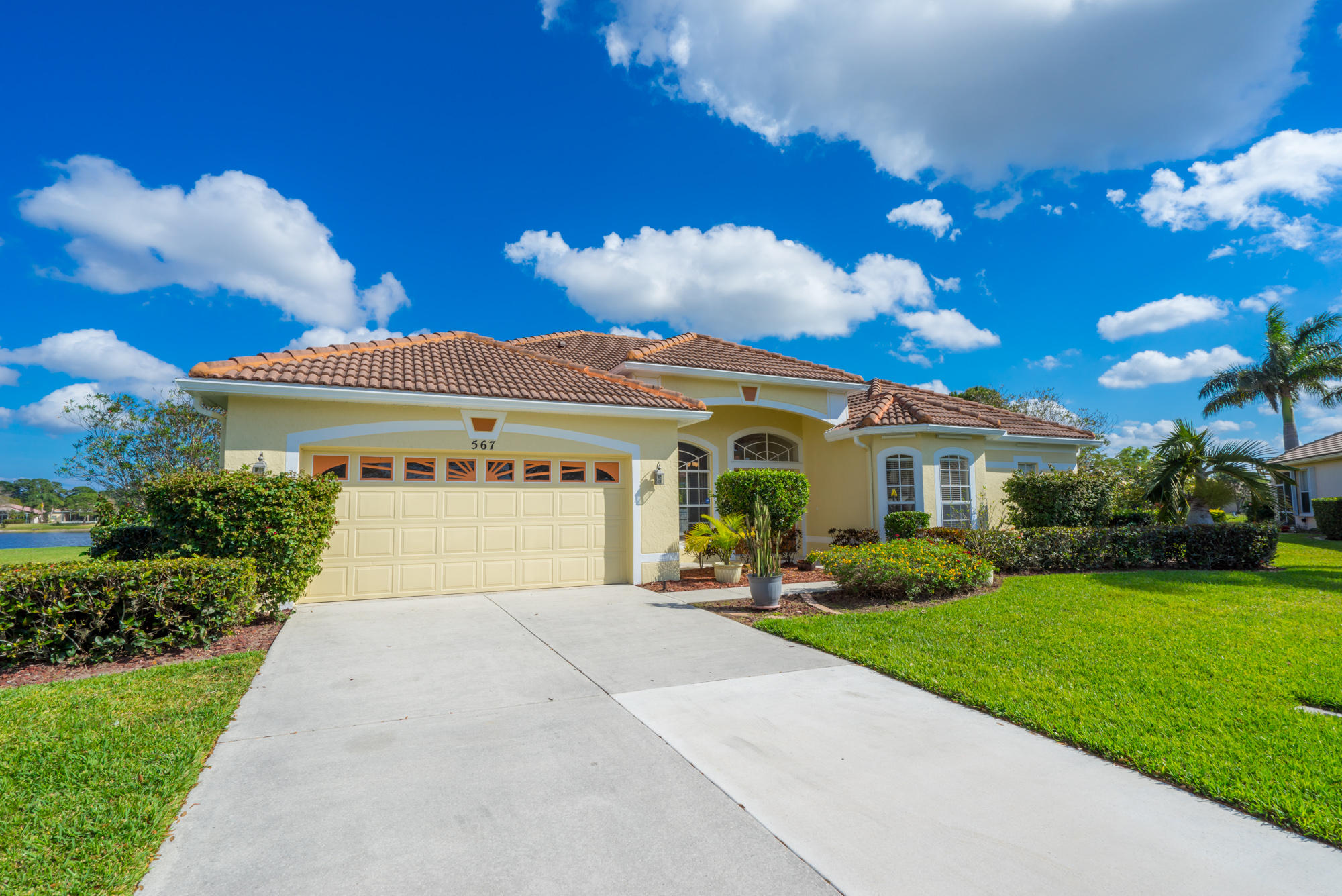 567 Southwest Spring Hill Point Port St. Lucie, FL 34986 - Photo 36 of 36 a front view of a house with a yard and potted plants