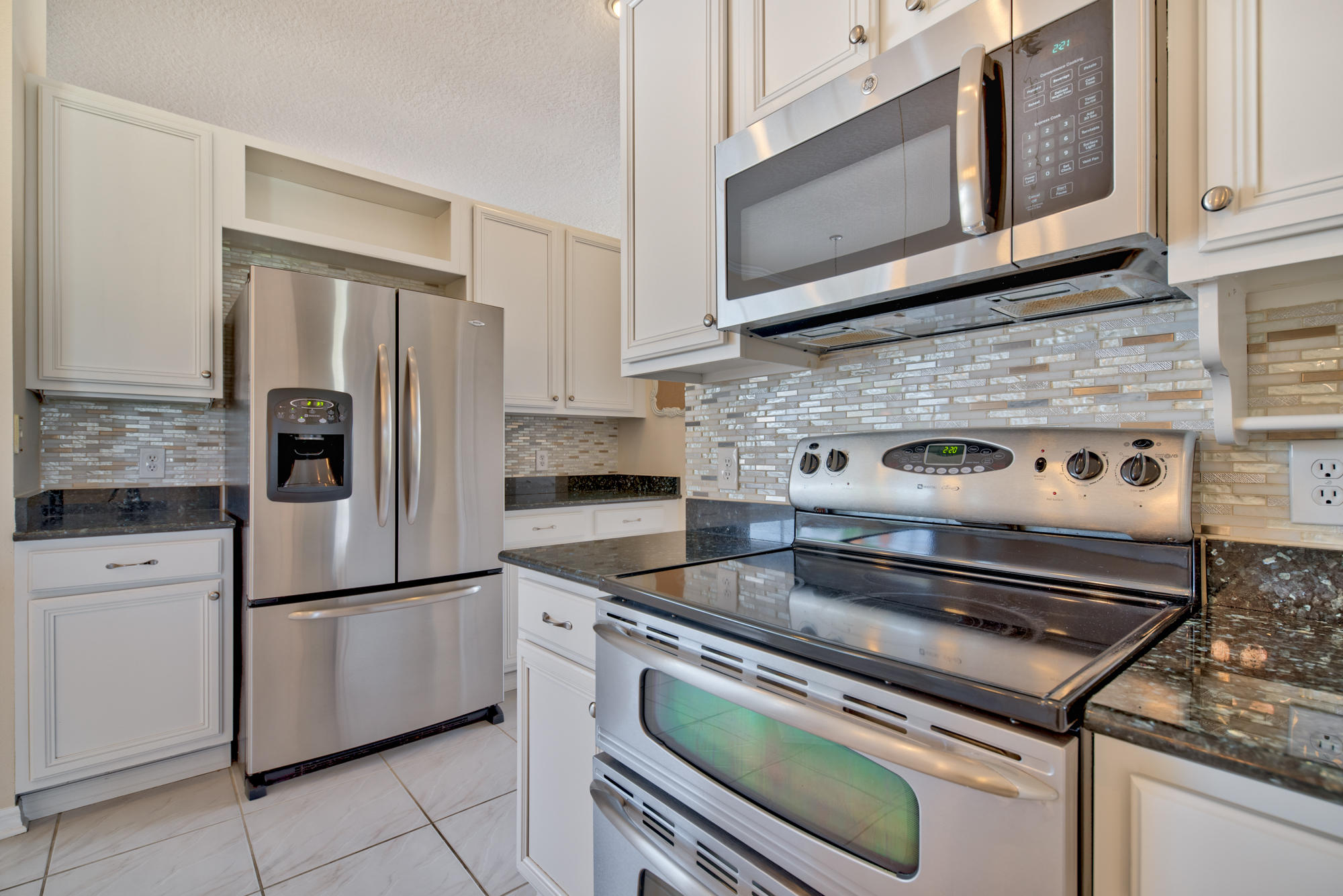 567 Southwest Spring Hill Point Port St. Lucie, FL 34986 - Photo 7 of 36 a kitchen with appliances cabinets and a counter top space