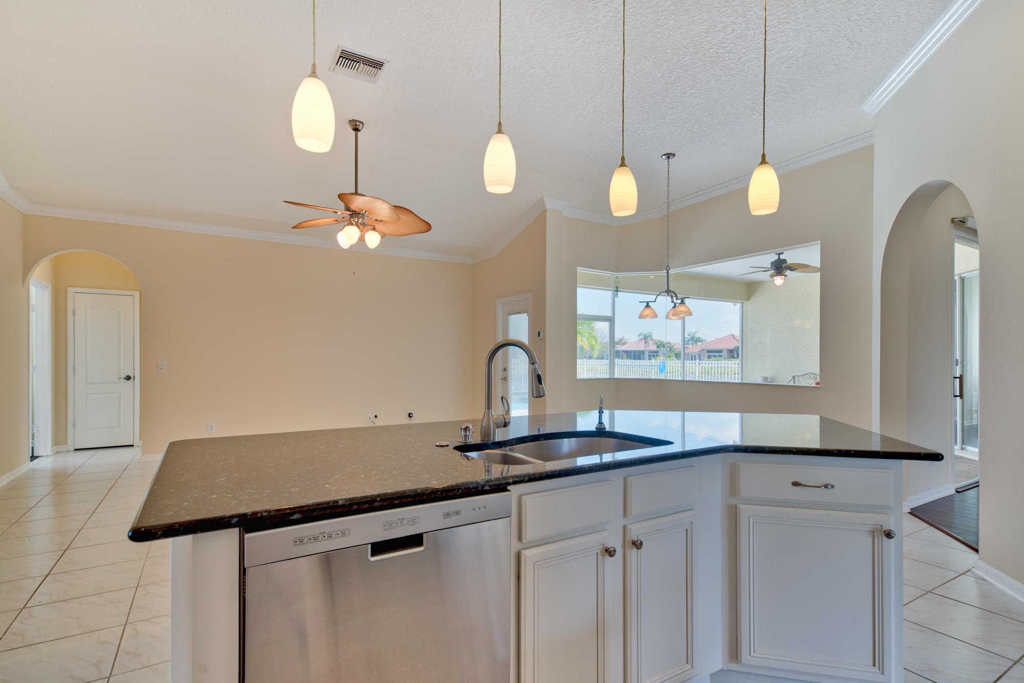 567 Southwest Spring Hill Point Port St. Lucie, FL 34986 - Photo 8 of 36 a view of a kitchen island a sink wooden floor and a chandelier