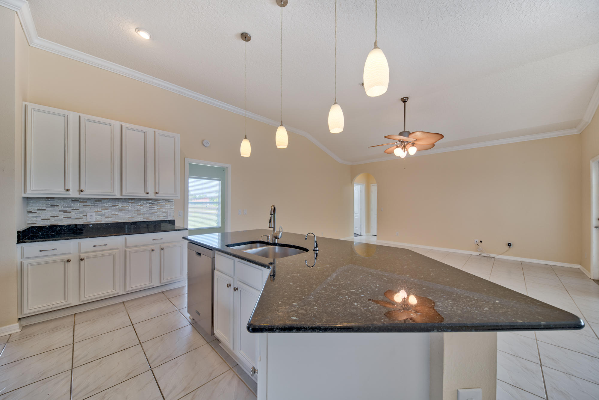 567 Southwest Spring Hill Point Port St. Lucie, FL 34986 - Photo 10 of 36 a kitchen with kitchen island granite countertop a stove a sink a counter space and cabinets