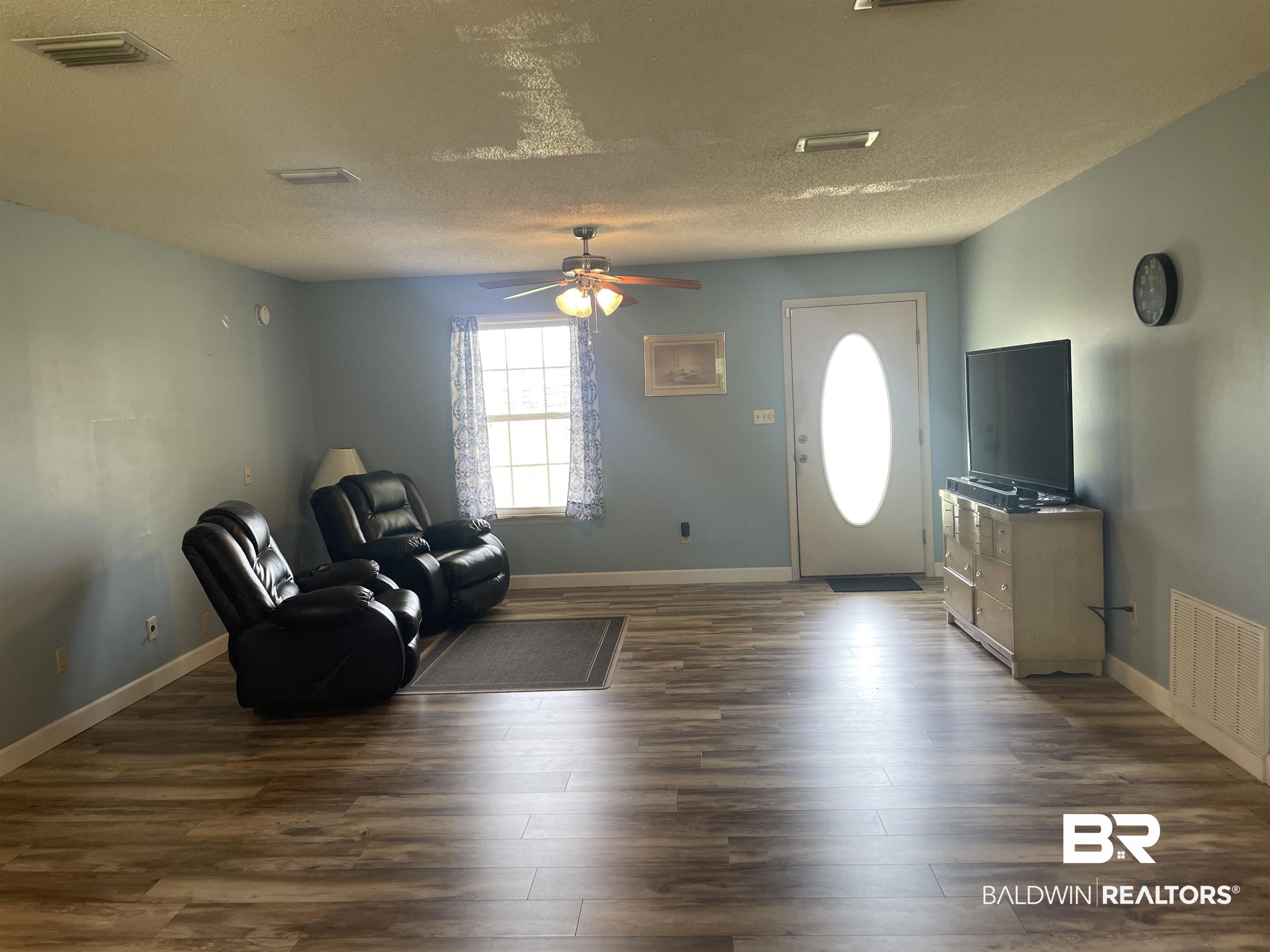 739 Smithfield Road Atmore, AL 36502 - Photo 3 of 18 Interior space featuring baseboards, visible vents, dark wood-style flooring, and a ceiling fan