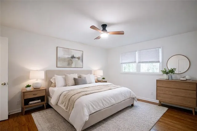 a bedroom with a bed and a dresser with wooden floor