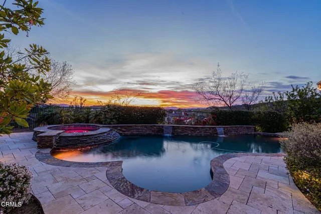 a view of swimming pool with a table and chairs under an umbrella
