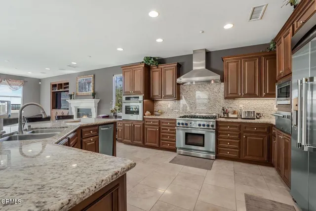 a kitchen with kitchen island granite countertop a stove sink and cabinets