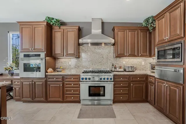 a kitchen with stainless steel appliances granite countertop a stove top oven a sink dishwasher and a stove
