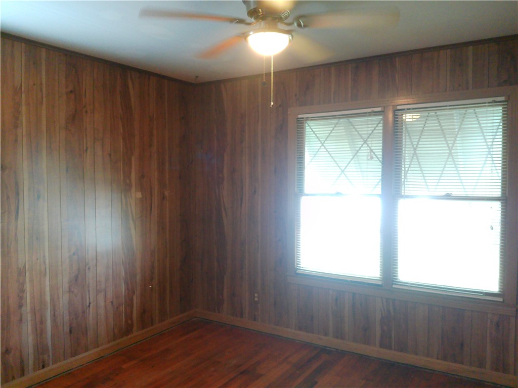 4322 Fir Street Corpus Christi, TX 78411 - Photo 11 of 17 an empty room with wooden floor and windows with curtains
