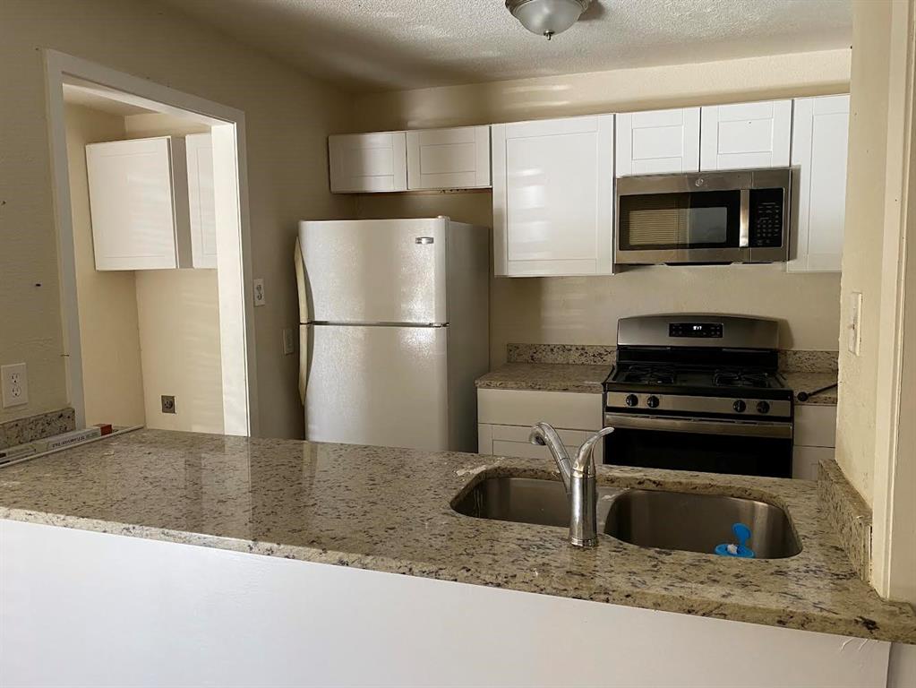 5105 Willie Street Fort Worth, TX 76105 - Photo 2 of 12 a kitchen with a refrigerator stove and microwave