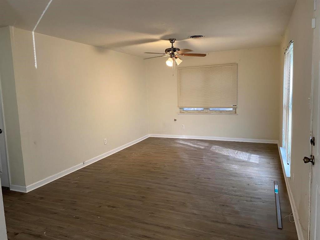 5105 Willie Street Fort Worth, TX 76105 - Photo 8 of 12 an empty room with wooden floor fan and windows